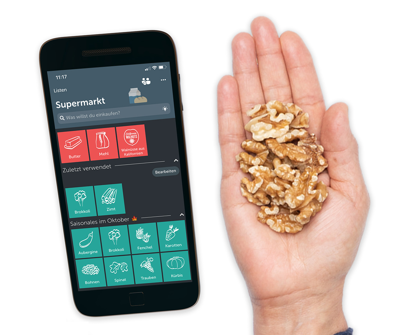 Handy und eine Hand gefüllt mit Walnüssen.